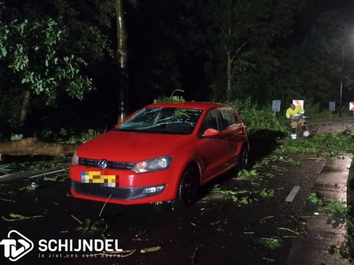 Noodweer: Auto botst op boom, gaten in wegdek, twee auto's onder boomtop